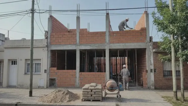 Casa en obra gris entre medianeras, con columnas de hormigón y muros de ladrillo en construcción